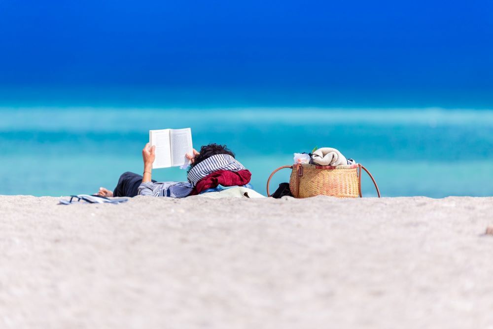 Una persona llegeix un llibre a la platja Foto: Dan Dumitriu