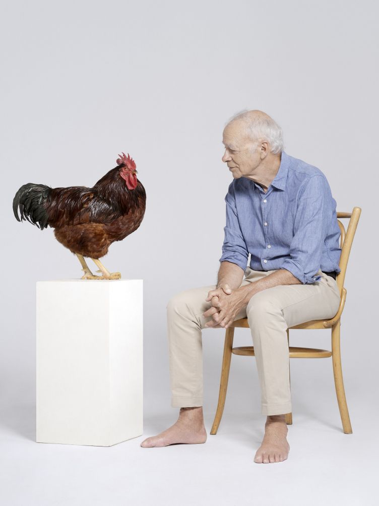 Peter Singer es mira una gallina. Foto: Petrina Hicks